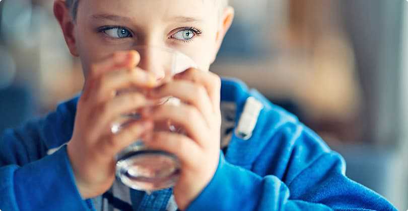 Child drinking clean water from a glass