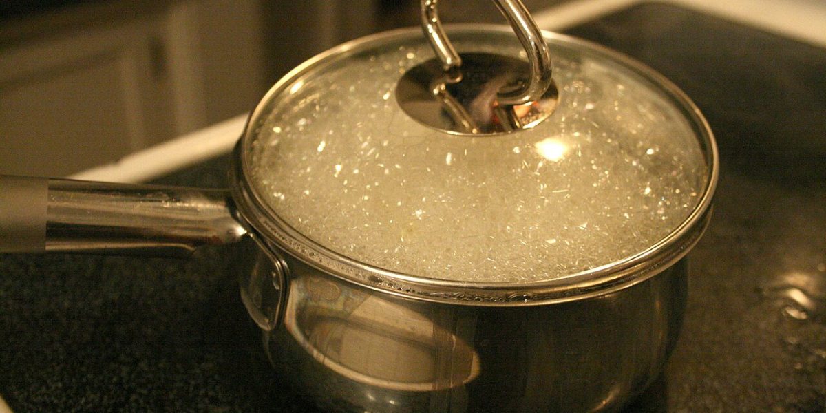 A pot of water at a rolling boil on a gas stove