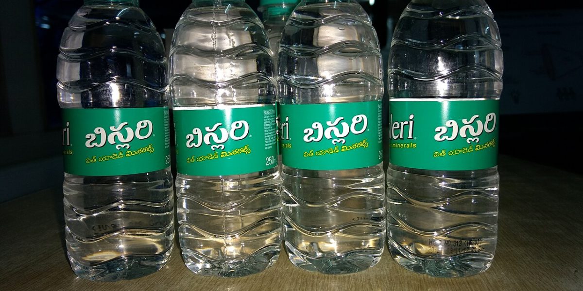 Rows of large blue 19-litre bottled water containers at a filling plant