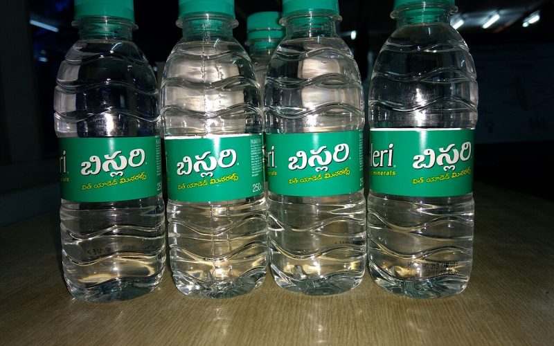 Rows of large blue 19-litre bottled water containers at a filling plant