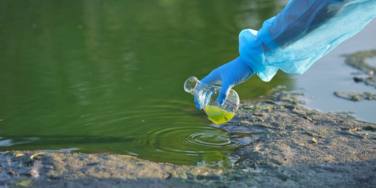 A digital TDS meter measuring a glass of drinking water